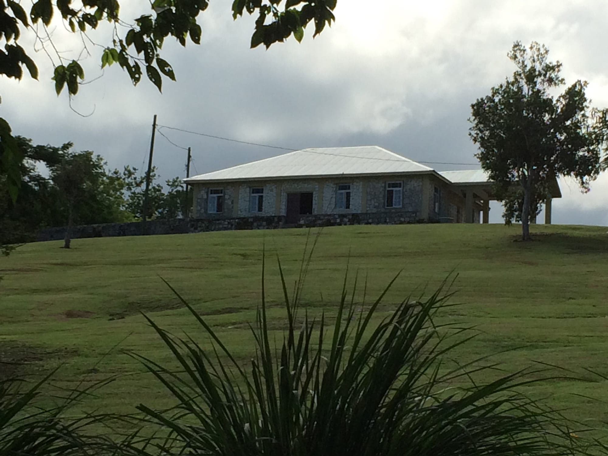 The hilltop hall under evening clouds